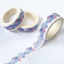Load image into Gallery viewer, photos shows white washi tape with a design of little blue, liac and purple flowers running along it.

