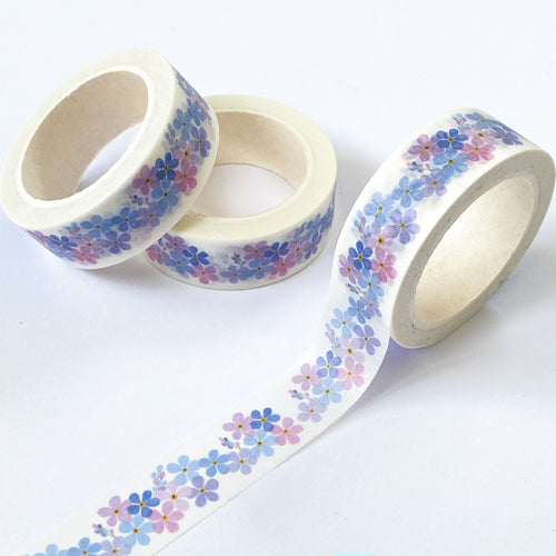 photos shows white washi tape with a design of little blue, liac and purple flowers running along it.