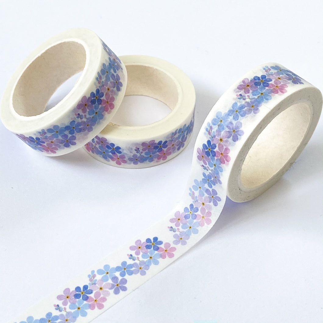 photos shows white washi tape with a design of little blue, liac and purple flowers running along it.