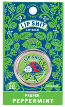 Load image into Gallery viewer, Proper Peppermint Lip S**t by Blue Q | £7.50. All natural, vitamin E fortified lip balm. The lip balm is contained within a round metal tin with a sticker on the front depicting a ladybird smiling with the words “Lip Shit” above. 
