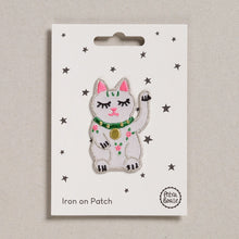 Load image into Gallery viewer, A sweet little waving lucky cat, white with pink ears and a green collar with a gold pendant on it.  There is also three little pink and green flowers on the front of the cat.  The patch is shown on its backing card which has small stars on it.
